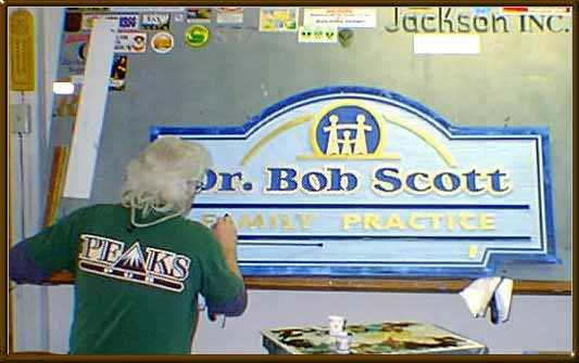 Me  applying clear coat to a sand blasted sign 